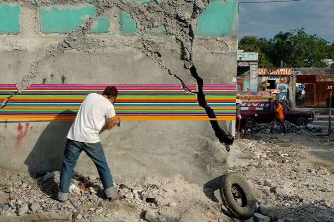 Member of Fungus Collective working on wall installation at 2nd Ghetto Biennale 2011 Photo: Peter Anderson